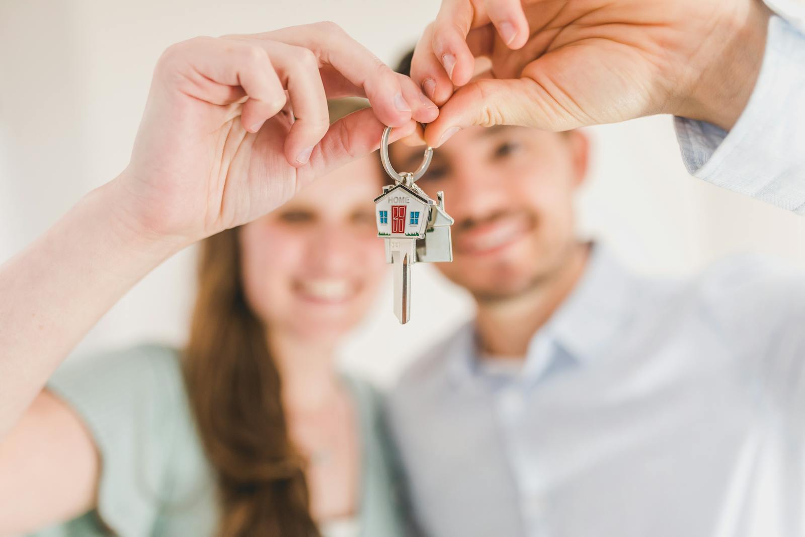 Happy homeowners with keys to their newly renovated home
